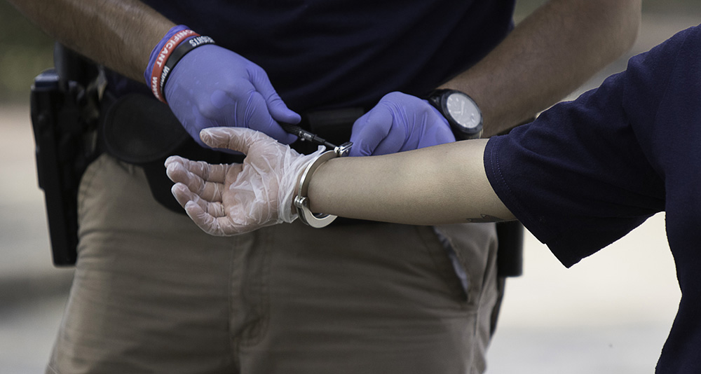 A gloved hand in handcuffs