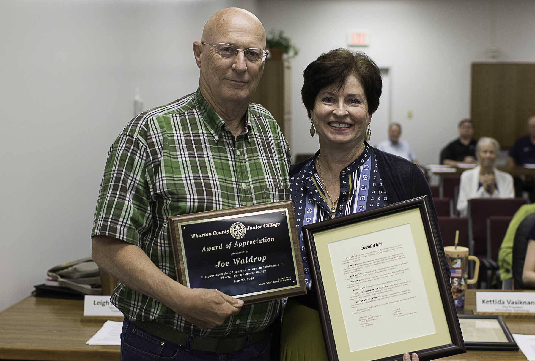 Wharton County Junior College Vice President of Instruction Leigh Ann Collins presents Band Instructor Joe Waldrop with a resolution and plaque recognizing his 21 years of service. 