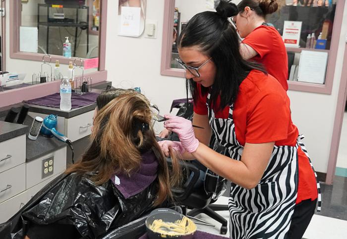 Wharton County Junior College's Cosmetology program offers courses in hair cutting, coloring, highlighting, skin care and nail technology. Pictured, foreground, is Kirsten Ochoa of El Campo. In the background is Kayla Hackworth of Bay City.